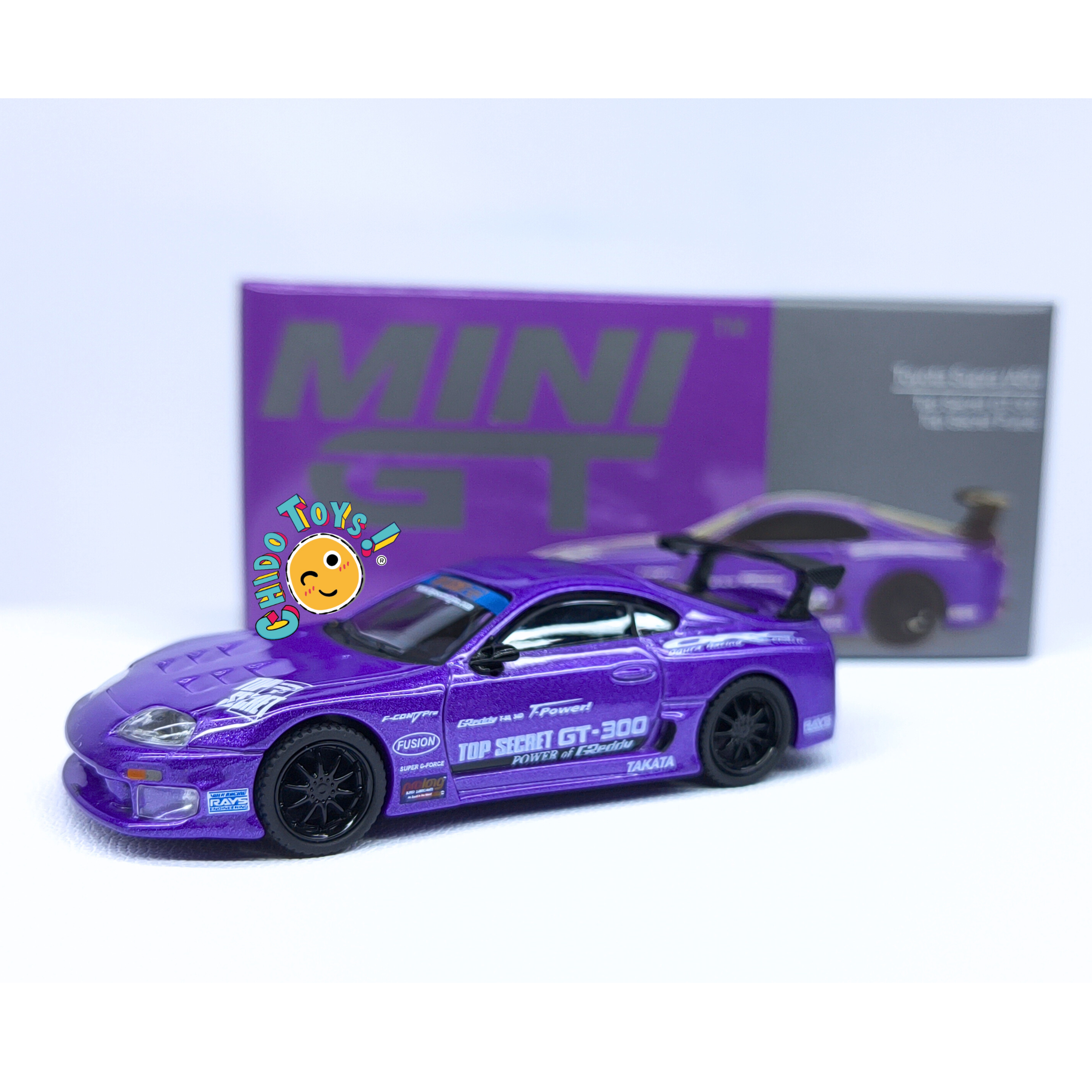 Mini GT Toyota Supra Top Secret 1:64 morado con carrocería metálica, gráficos GT-300, alerón trasero y llantas de goma