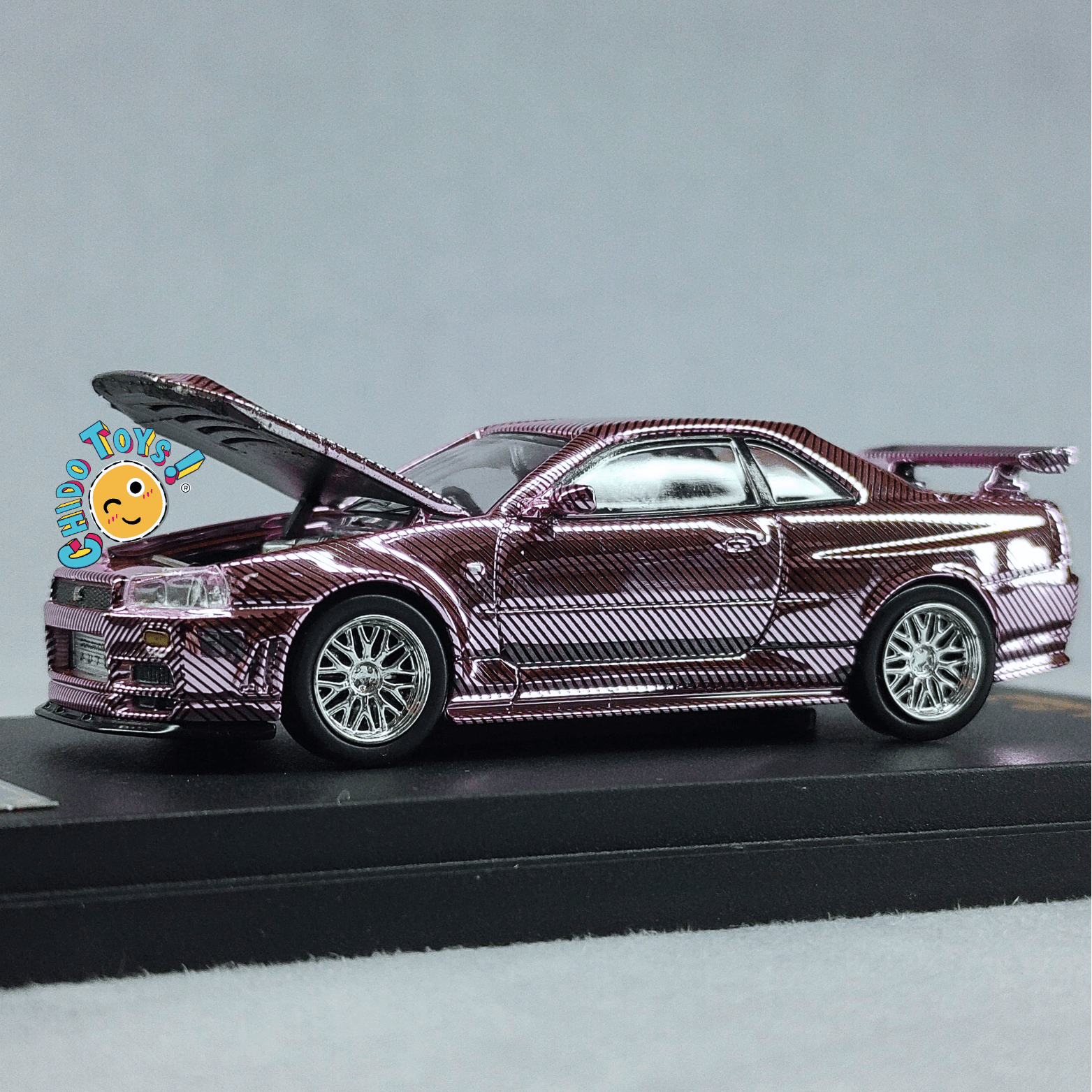 Auto a escala 1:64 Demon King Auto Nissan Skyline GT - R R34 – Motor detallado y cofre funcional - Chido Toys