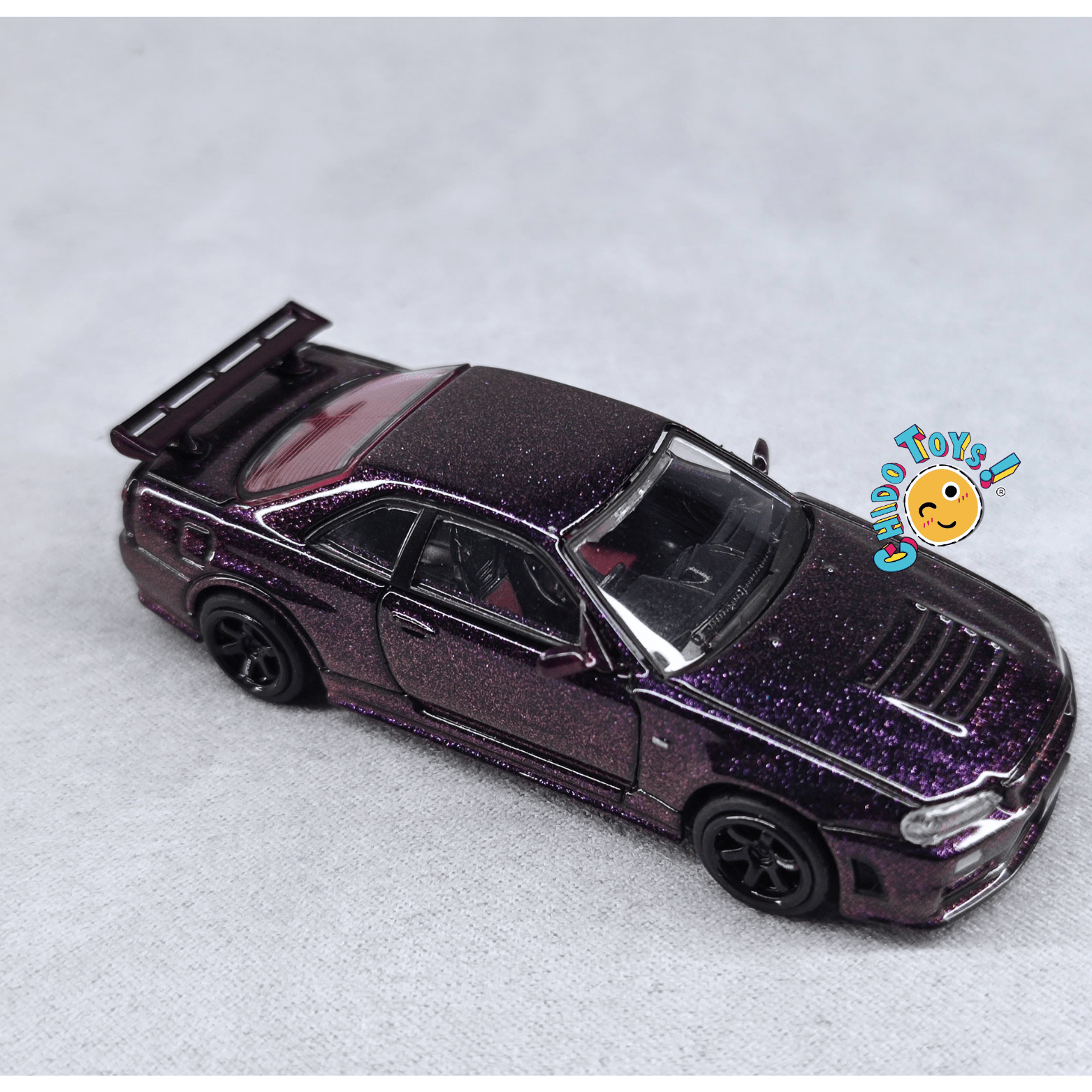 Auto a escala 1:64 TopArt Nissan Skyline GT - R R34 Z - Tune Camaleón con Base y Capelo - Chido Toys