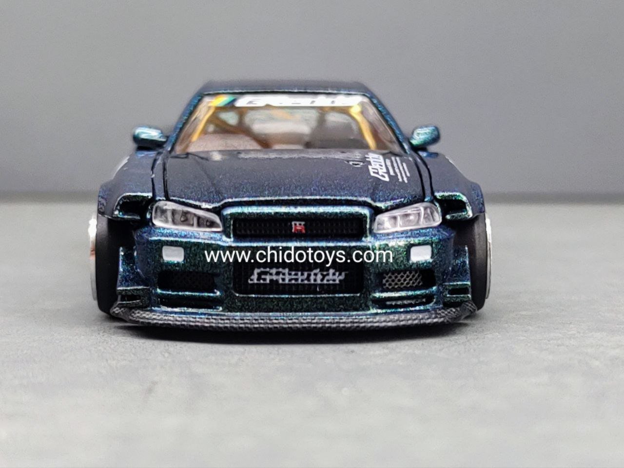 Auto a escala marca Mini GT, Modelo Nissan Skyline GT - R (R34) Kaido Works GReddy - Chido Toys