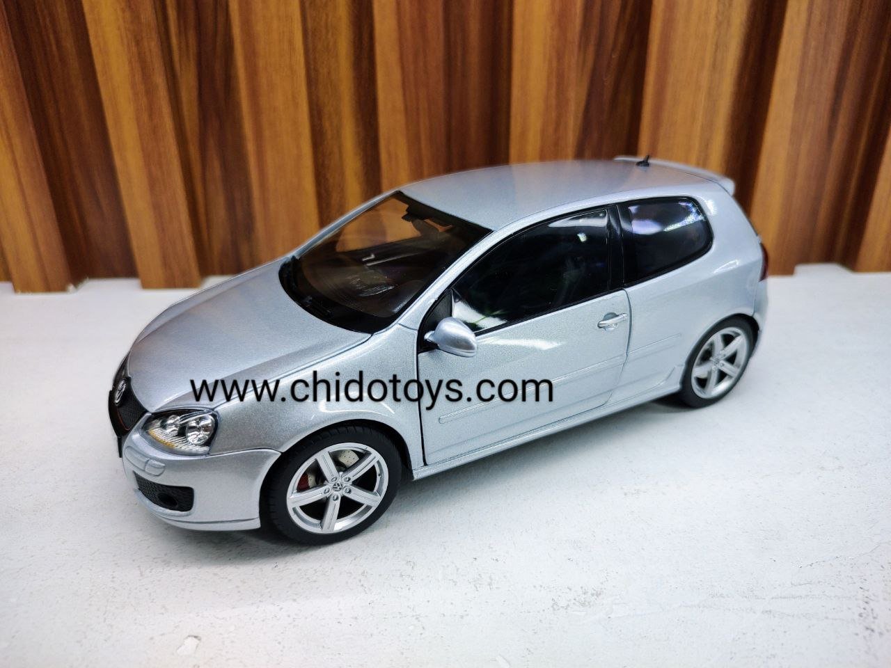 Modelo a escala 1:18 Volkswagen Golf GTI Pirelli color plata de Norev, con puertas, cofre y cajuela abatibles.