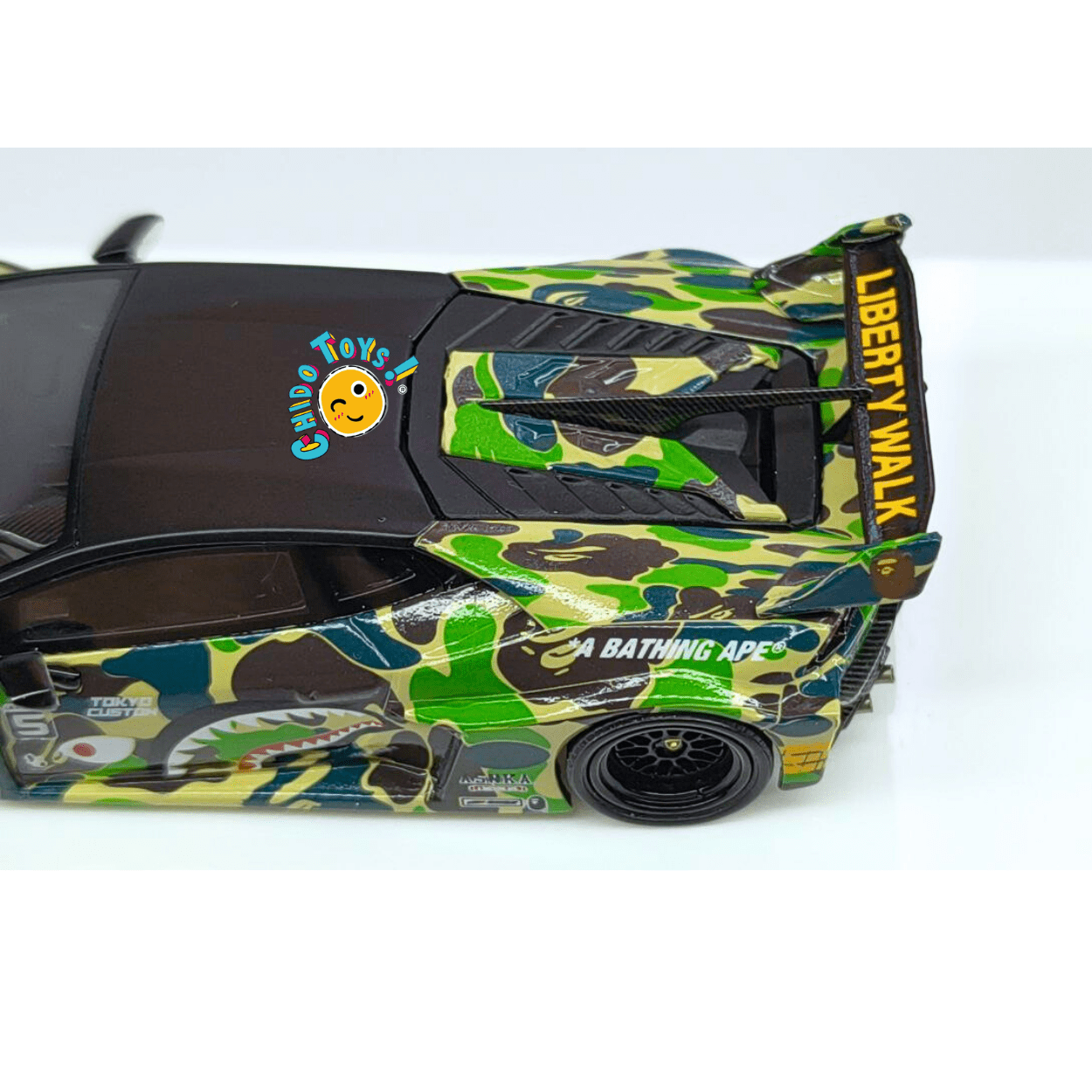 Lamborghini Huracán GT Liberty Walk “A Bathing Ape” Camuflaje Verde 1:64 con Base y Capelo – Flame Models - Chido Toys