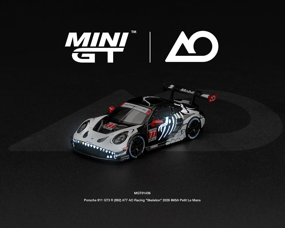 Próximo a llegar 🚗🔥 Mini GT 1:64 Porsche 911 GT3 R (992) #77 AO Racing “Skeleton Rexy” 2026 IMSA Petit Le Mans – (Brilla en la oscuridad) - Chido Toys