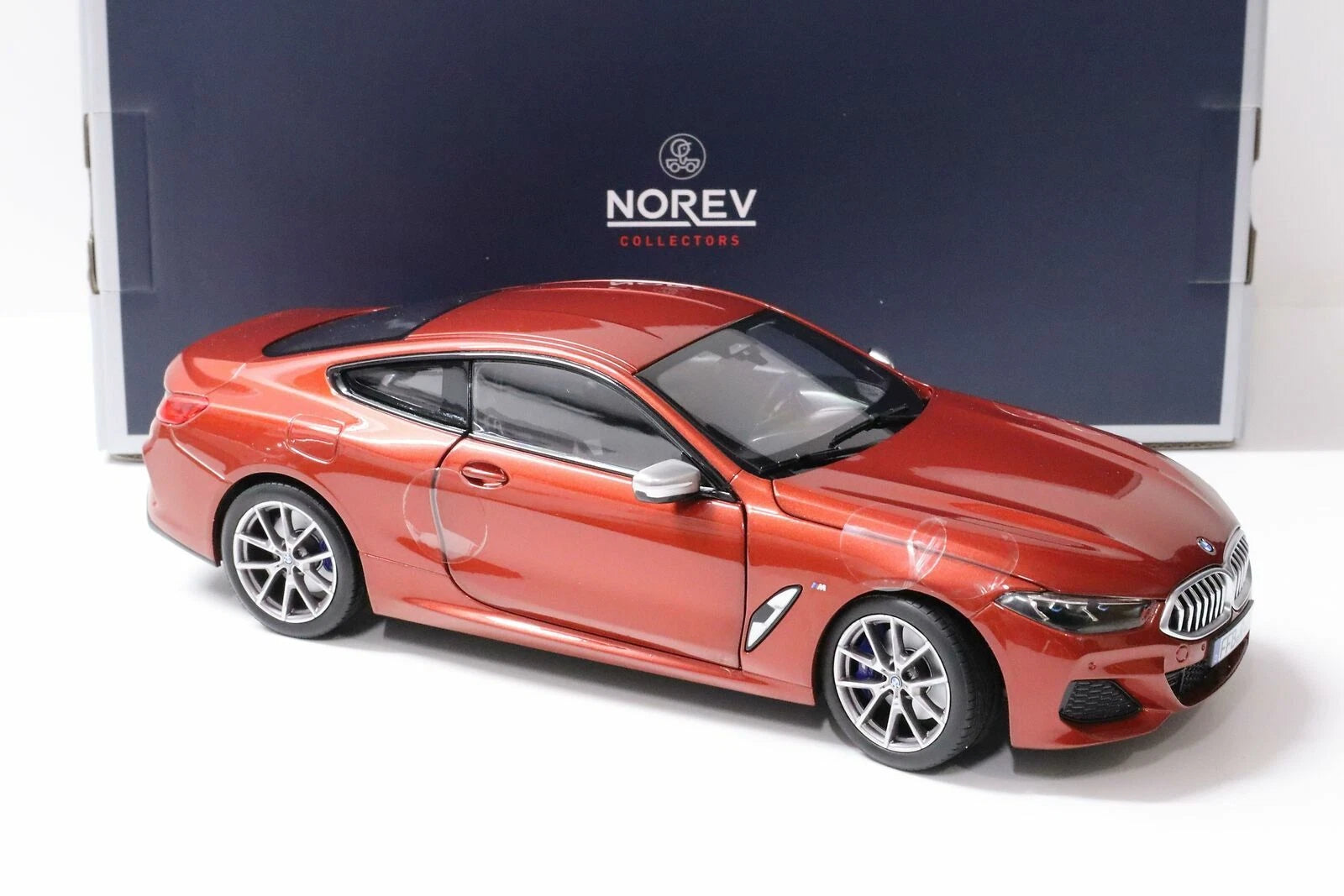 Norev BMW M850i Coupé 2019 1:18 naranja metálico, diecast con llantas de goma y apertura de puertas, cofre y cajuela.