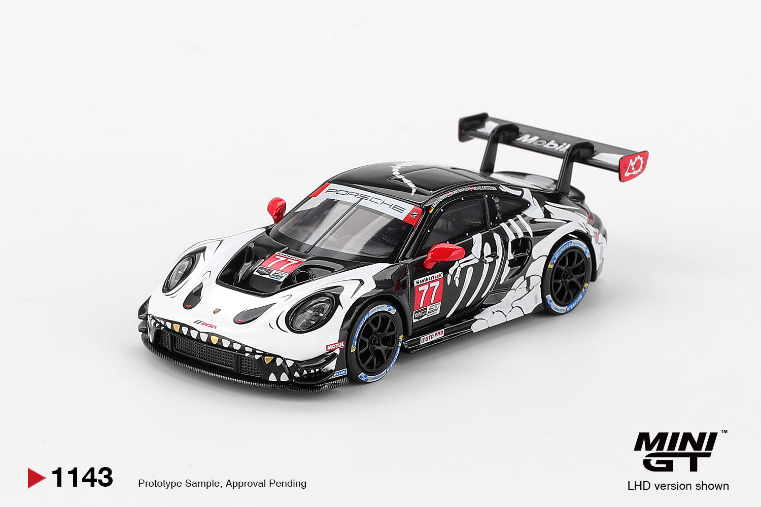 Mini GT Porsche 911 GT3 R Rexy número 77 IMSA escala 1:64 con decoración de dinosaurio, alerón de competición y llantas de goma.