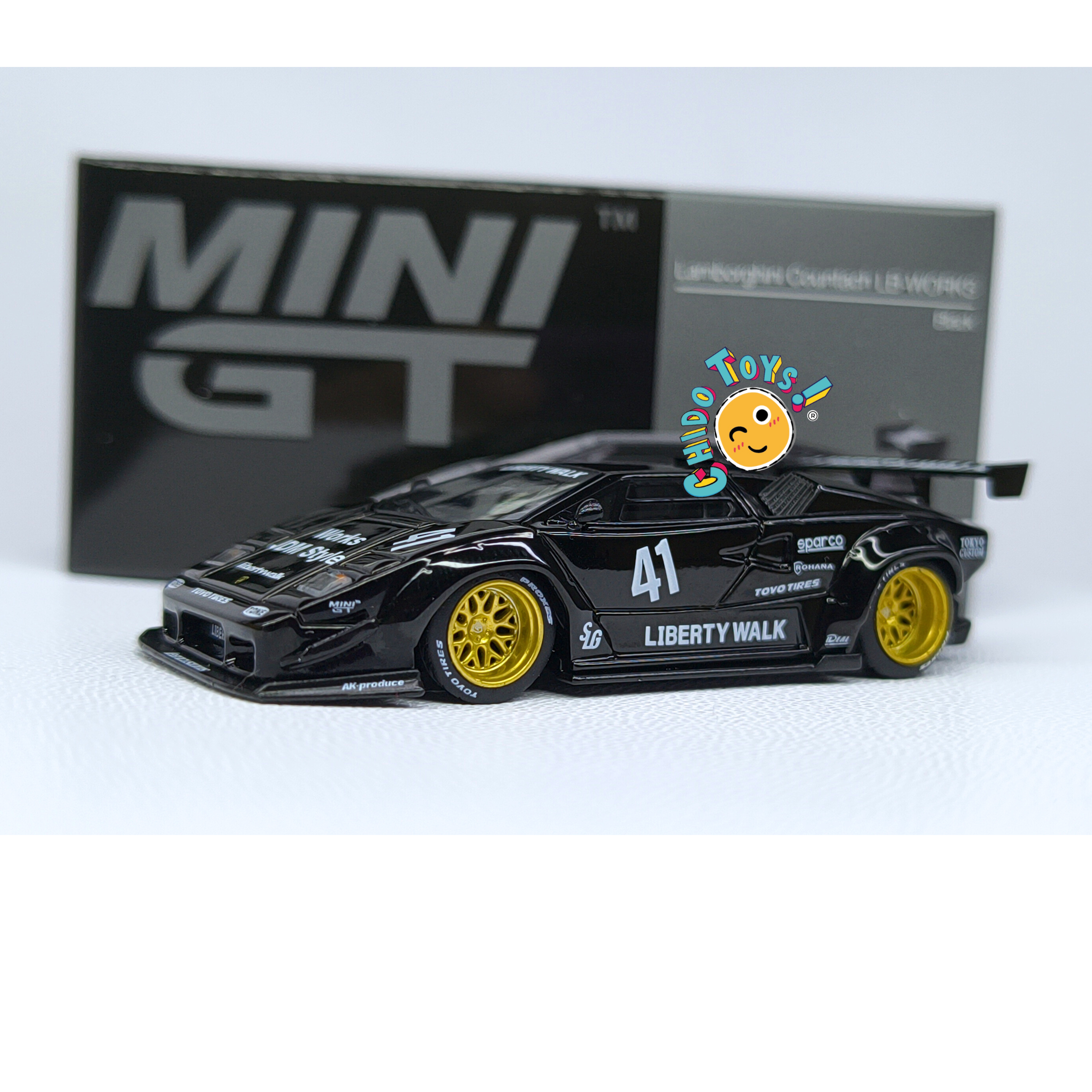 Mini GT Lamborghini Countach LB-WORKS 1:64 negro con carrocería metálica, rines dorados, alerón trasero y llantas de goma