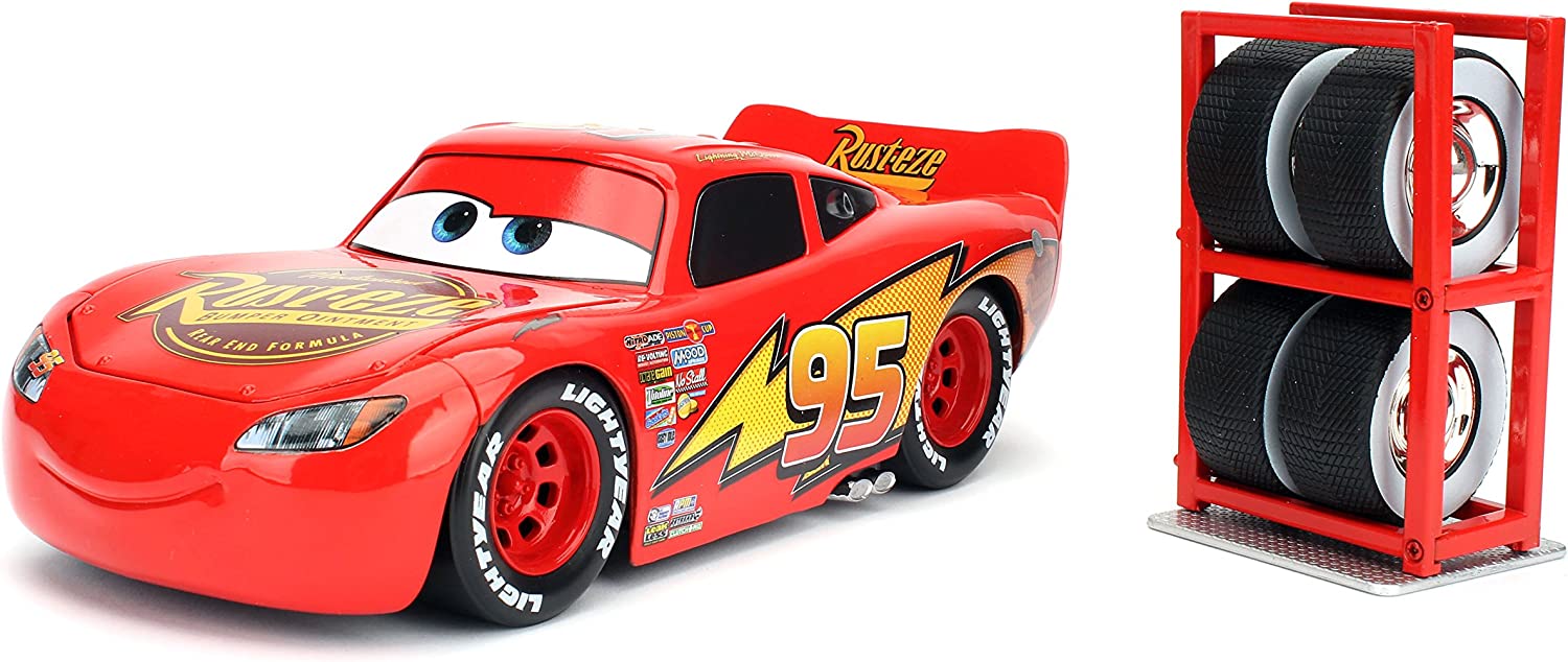 Lightning McQueen Jada 1:18 rojo con apertura de cofre, llantas de goma Lightyear y estantería de neumáticos incluida