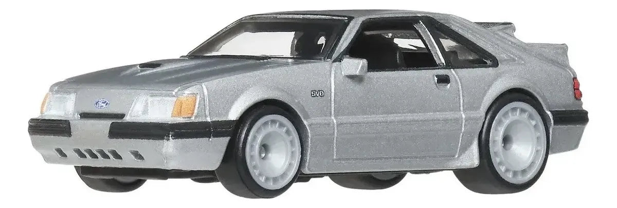 Hot Wheels Premium '84 Mustang SVO escala 1:64 color plata con construcción Metal/Metal y llantas Real Riders de goma en blíster Power Trip.