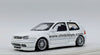 Focal VW Golf GTI Mk4 escala 1:64 blanco con carrocería de metal, cofre abatible, llantas de goma y capelo transparente.