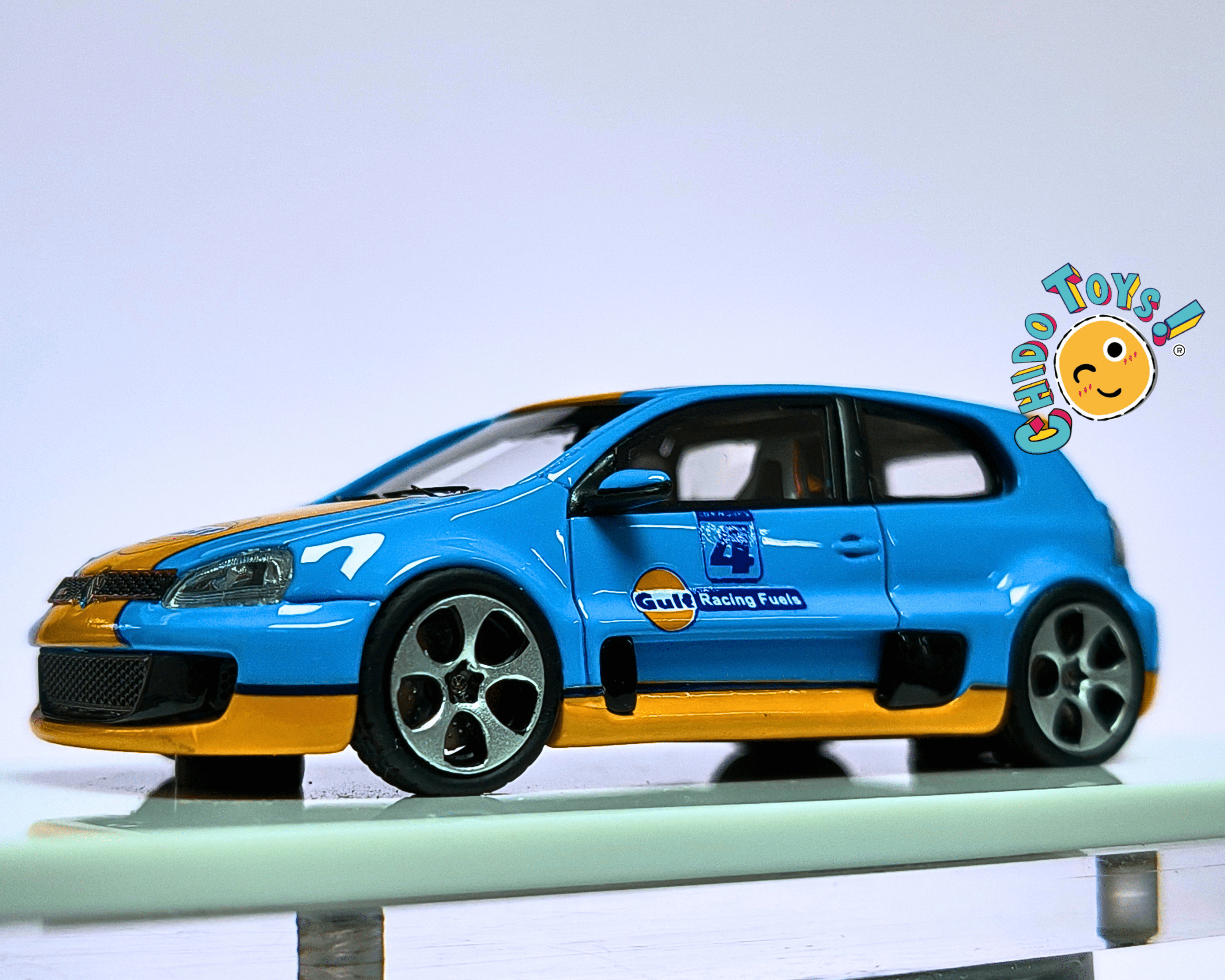 Volkswagen Golf GTI Gulf Racing 1:64 con Capelo Acrílico y Llantas de Goma - Chido Toys